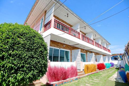 une maison avec un balcon sur le côté de celle-ci dans l'établissement PloyPhailin พลอยไพรินรีสอร์ท, à Ko Larn