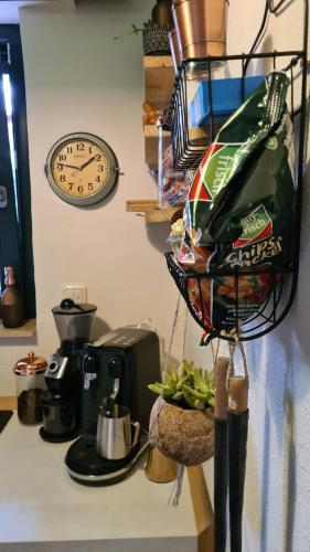 a kitchen counter with a clock and a coffee maker at Boutique Apartments Benz I-III in Bergisch Gladbach