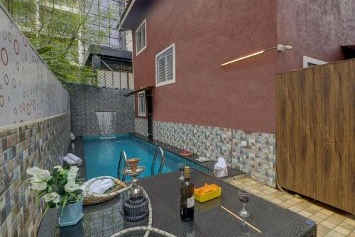 a patio with a table and a swimming pool at Ludo Private Pool Villa, WiFi-Caretaker-Parking, North Goa in Baga