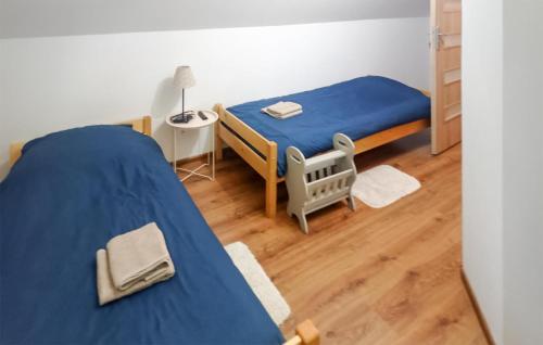 una camera con un letto blu e una sedia di 4 Bedroom Lovely Home In Rybical a Ryn