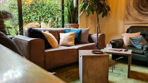 a living room with a brown couch and a table at Boutique Apartments Benz I-III in Bergisch Gladbach