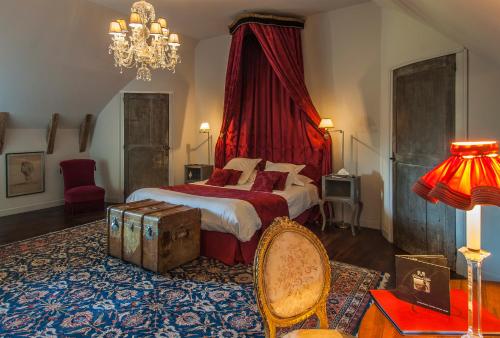 a bedroom with a bed with a red canopy at Château de Labro - Teritoria in Onet le Château