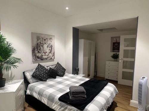 a bedroom with a bed and a painting of a tiger at The Broadway Beach House with Hot tub in Kent