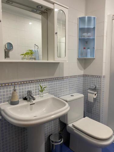 uma casa de banho com um lavatório branco e um WC. em SUEÑOS DEL MAR em Motril