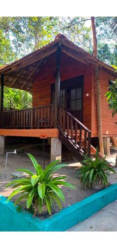a wooden cabin with a porch and a deck at Eco Cabanas Marakolliya in Tangalle