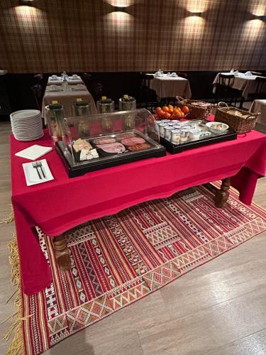 une table avec une nappe rose et de la nourriture dans l'établissement Hotel du Pot d'Etain, à Châlons-en-Champagne
