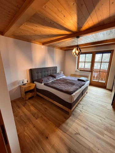 1 dormitorio con cama y techo de madera en Home-Schusterwastl, en Grossarl