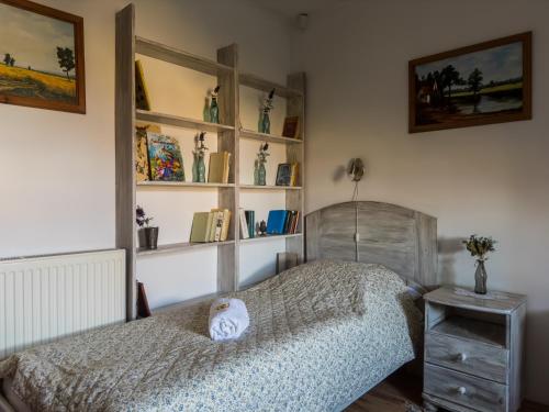 a bedroom with a bed and shelves of books at Edvy Malom Apartmanok Pápa in Pápa