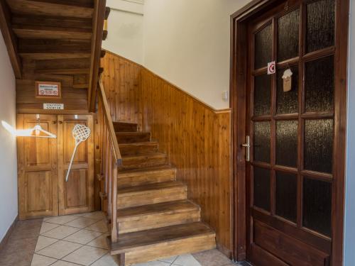 a hallway with a wooden staircase next to a door at Edvy Malom Apartmanok Pápa in Pápa