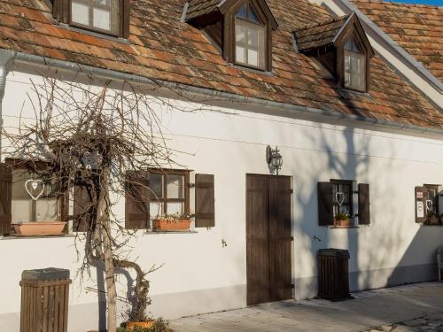 a white building with windows and a roof at Edvy Malom Apartmanok Pápa in Pápa