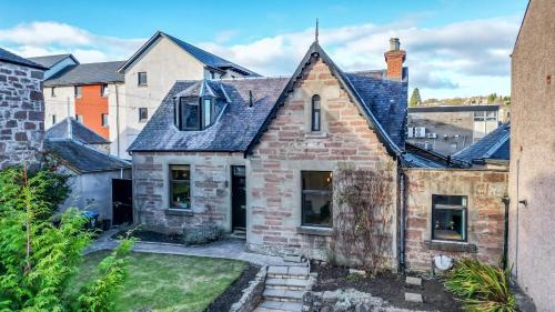 uma antiga casa de tijolos com um telhado preto em Fontain House: 4 bedroom Victorian villa em Blairgowrie