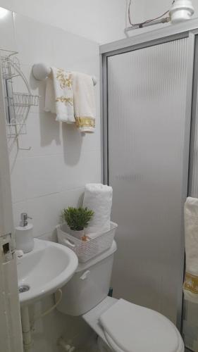a white bathroom with a toilet and a sink at El descanso in Bogotá