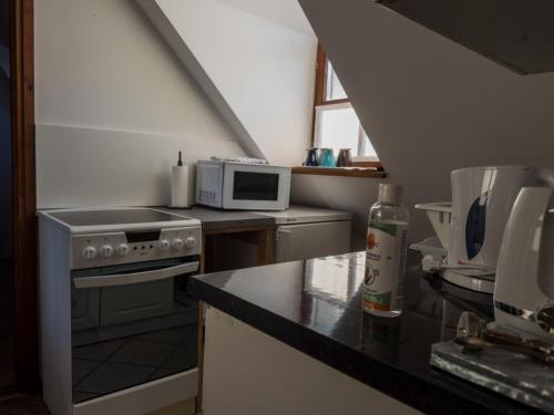 a kitchen with a stove and a microwave on a counter at Edvy Malom Apartmanok Pápa in Pápa