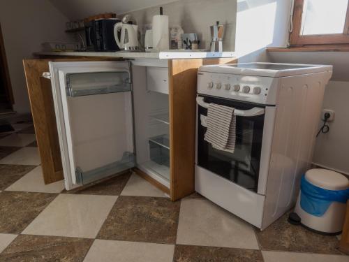 a kitchen with a stove and a dishwasher at Edvy Malom Apartmanok Pápa in Pápa