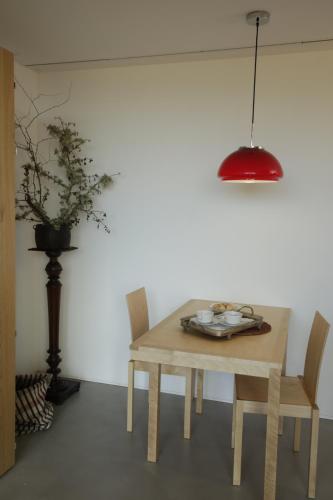 a wooden table with two chairs and a red lamp at Leiras do Tempo - Adults Nature Retreat - Tomadinha 3 Cottage - Gerês National Park in Terras de Bouro