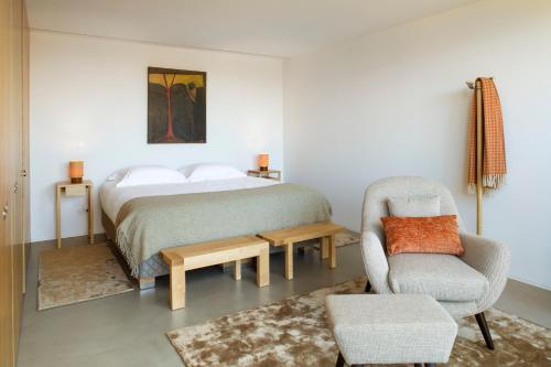 ein Schlafzimmer mit einem Bett und einem Stuhl in der Unterkunft Gerês - Leiras do Tempo - Cottage Tomadinha 3 in Terras de Bouro