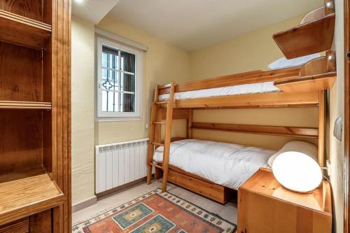 a bedroom with two bunk beds and a window at Lujo y comodidad en Sierra Nevada in Monachil