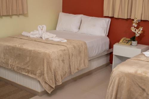 a hotel room with two beds with towels on them at Diosamar Hotel y Suites in El Valle