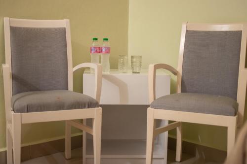 duas cadeiras e duas garrafas de água numa mesa em Diosamar Hotel y Suites em Santo Domingo