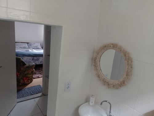 baño con espejo, lavabo y cama en Quartos para Hospedagem da Casa Amarela, en Campos do Jordão