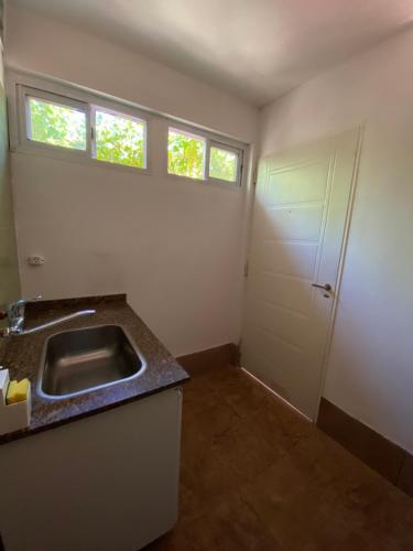 a small kitchen with a sink and a door at Mielcita in Tinogasta