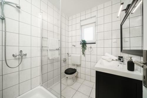 a bathroom with a toilet and a sink and a shower at Villa Pearl in Tribunj