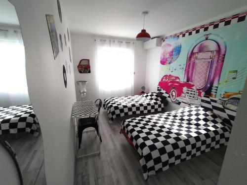 2 Betten in einem schwarz-weiß karierten Zimmer in der Unterkunft GITE diner AMERICAIN in Clévilliers