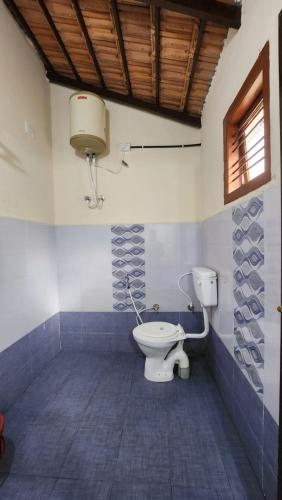 łazienka z toaletą i oknem w obiekcie The Wind Chime - SUPRAD Estate w mieście Suntikoppa