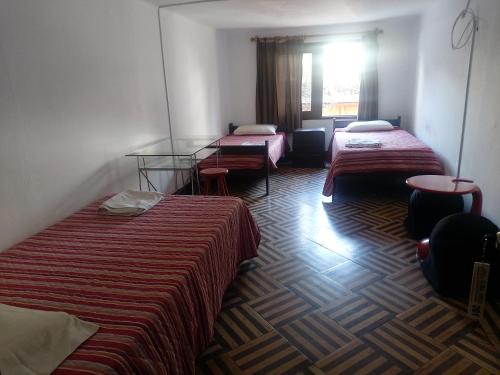 a hotel room with two beds and a window at Global Family Backpackers Hostel in Lima