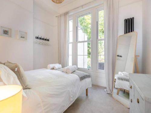 um quarto branco com uma cama e uma janela em Beach Apartment em Hastings