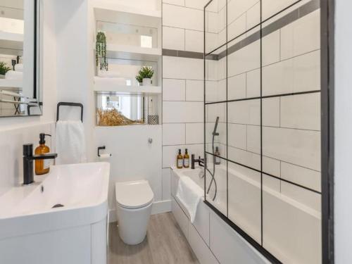 bagno bianco con servizi igienici e lavandino di Beach Apartment a Hastings