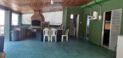 a kitchen with two chairs and a table with a fireplace at Sitio Terra Azul in Guarulhos