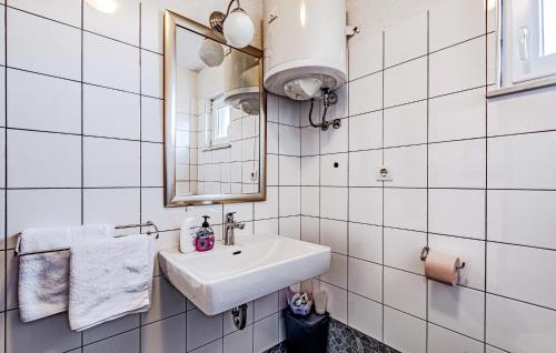 a white bathroom with a sink and a mirror at Nice Home In Poljica With Wi-fi in Poljica