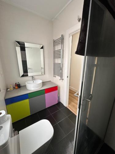 a colorful bathroom with a sink and a toilet at León es sueño in León
