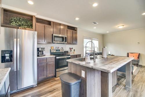 a kitchen with wooden cabinets and a large kitchen island at Grand Lake Views Pet-Friendly Jay Getaway! in Jay