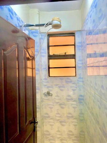 y baño con ducha y ventana. en VICTOR'S SERENE STAYS, en Nairobi