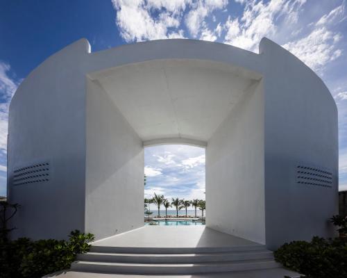 a white building with stairs leading to a pool at iSea by the sea in Ninh Van Bay