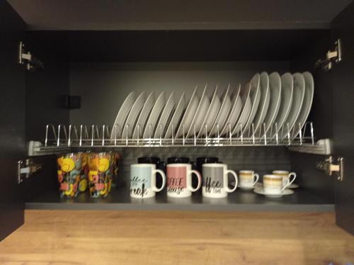 a row of coffee mugs sitting on a shelf at Minimal Two-Floor Apartment in Thessaloniki
