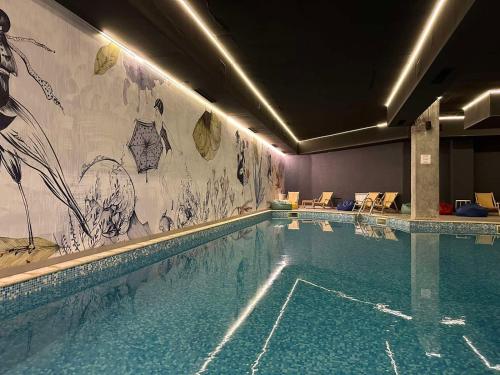 uma piscina num hotel com uma pintura na parede em Sana Ski apartment 313A in Flora, Borovets em Borovets