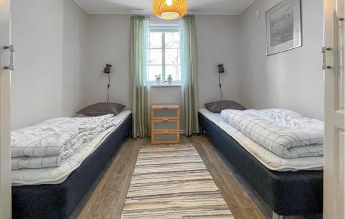 a room with two beds and a window at Amazing Home In Gislaved With 4 Bedrooms, Sauna And Wifi in Hornbetan