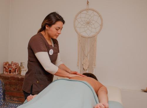 a woman getting a massage from a woman at Hotel Boutique & Spa Puerto Natura in Valparaíso