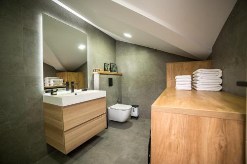 a bathroom with a sink and a toilet at ARHEYA 8 apart/АРХЕЯ 8 апартамент за гости in Karlovo