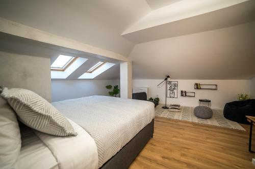 a bedroom with a large bed and a skylight at ARHEYA 8 apart/АРХЕЯ 8 апартамент за гости in Karlovo