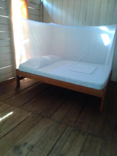 1 cama en la parte superior de un suelo de madera en Hostal Dasilva en San Martín de amacayacu en San Martín