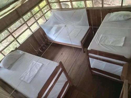 a group of three beds in a room at Hostal Dasilva en San Martín de amacayacu in San Martín