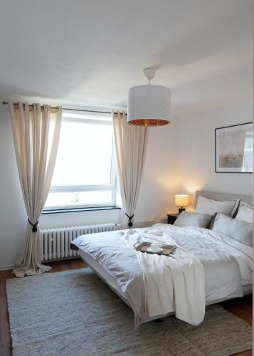 - une chambre avec un grand lit et une fenêtre dans l'établissement Elegantes & Modernes Messe Apartment, Hannover, Laatzen, à Hanovre