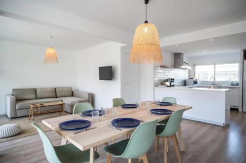 une salle à manger avec une table en bois et des chaises vertes dans l'établissement Magnificent apartment close to the beach with sea view, à Antibes