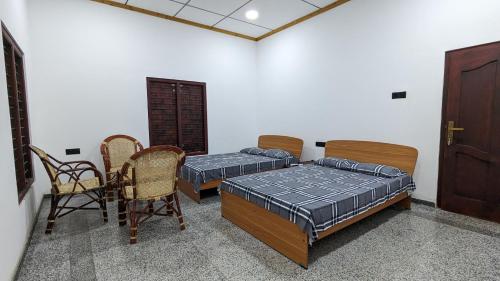 Pokój z 2 łóżkami, stołem i krzesłami w obiekcie KATHIR Guest House w mieście Dżafna