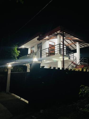 Casa blanca con balcón por la noche en Villa Arshu., en Bentota