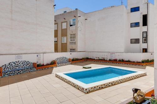 uma piscina num pátio com um edifício em Studio Apartment Santana Habaneras - 18 at Beach with Garage, Pool and Lift em Torrevieja